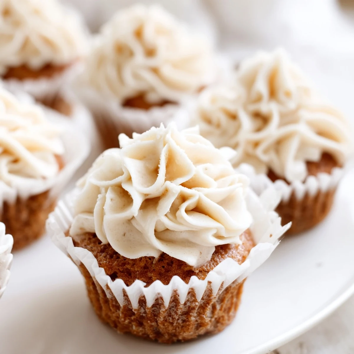Close-up of baked vanilla cupcakes topped with sweet, creamy homemade buttercream frosting.