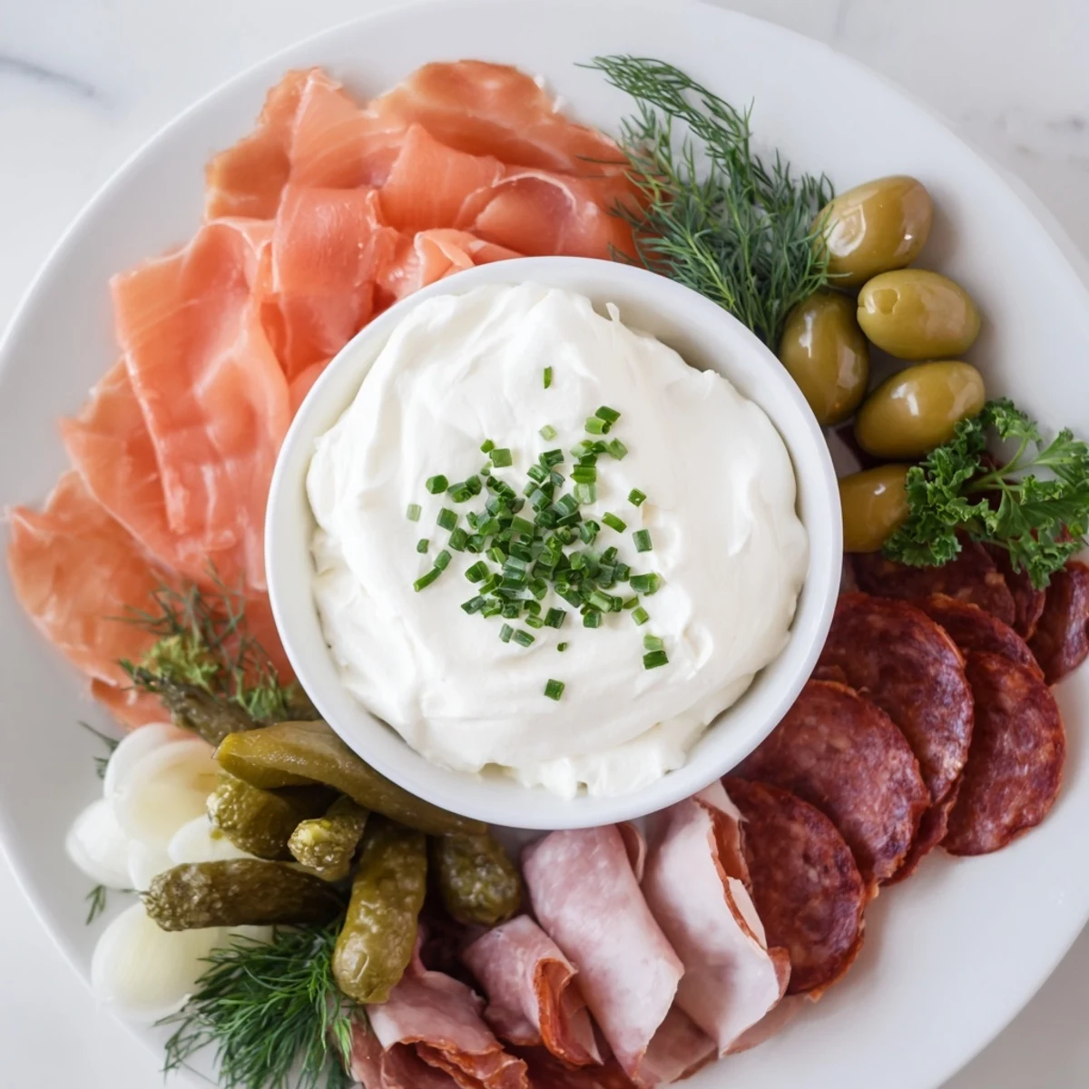 A delicious Compass Rose appetizer with a vibrant array of cured meats and a flavorful creamy dip.
