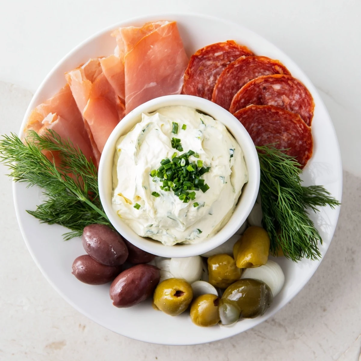Elegant presentation of a Compass Rose, displaying sliced meats, olives, and a zesty dip for easy entertaining.