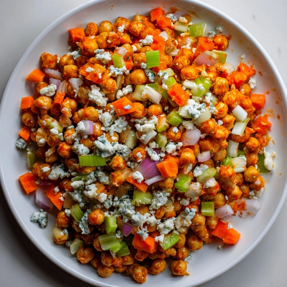 A vibrant bowl of Buffalo Chicken Bean Salad, ready to enjoy's crunchy vegetables and creamy sauce.