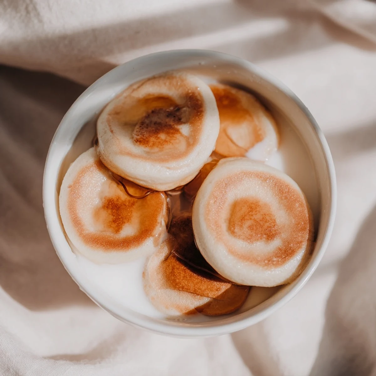 Close-up of adorable fluffy pancake cereal showing the mini pancakes drizzled with syrup.