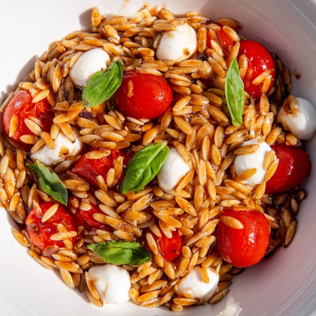 Close-up of a vibrant Caprese Orzo Salad, showcasing fresh basil and Italian flavors everyone loves.