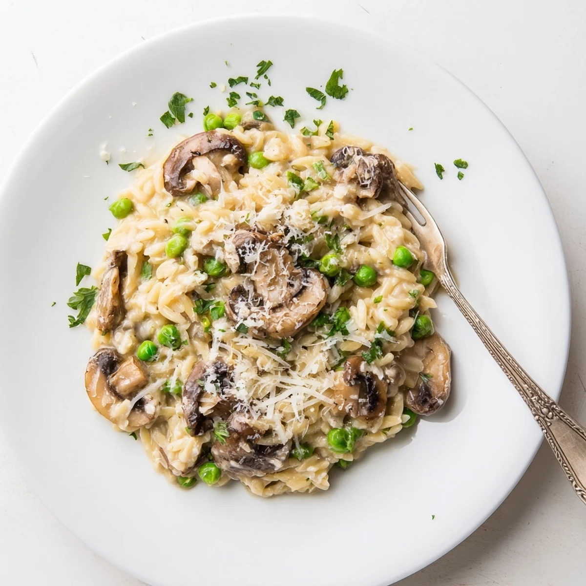 A close-up of creamy Orzo Mushroom Risotto-Style in a rustic bowl, garnished with fresh parsley and grated Parmesan.