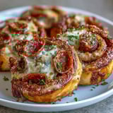 A slice of Irresistible High Protein Pepperoni Pizza Rolls reveals a hearty filling of seasoned lean beef, zesty sauce, and gooey cheese inside soft dough. 