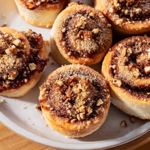Golden, glistening maple pecan sticky buns, with a caramel glaze and chopped pecans topping.