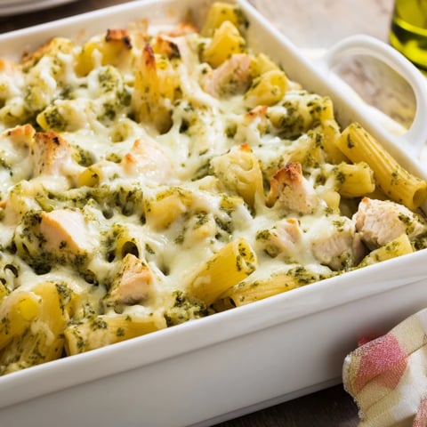 Golden-baked Pesto Chicken Pasta Bake with melted mozzarella, al dente penne, and vibrant basil pesto served in a casserole dish.