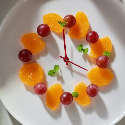 Freshly assembled Grape and Orange Slice Clock Face featuring bright citrus and ruby grapes, ready to serve for brunch.