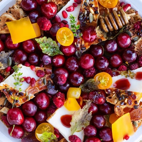 A vibrant Crimson & Gold Gala appetizer: view the festive, colorful arrangement of cheese and roasted peppers.