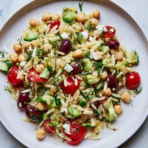 Bright, zesty Greek lemon-orzo bean salad with a drizzle of lemon vinaigrette, perfect for summer picnics.