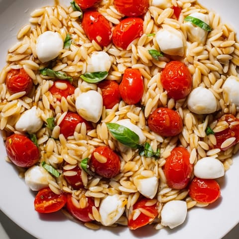 Refreshing Caprese Orzo Salad with a glistening balsamic vinaigrette, perfect for a summer lunch.