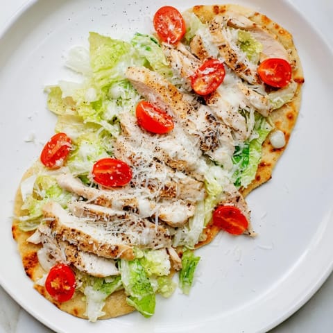 Caesar Chicken Flatbread baked to perfection with a golden crust, layered with tender chicken and shaved Parmesan.  