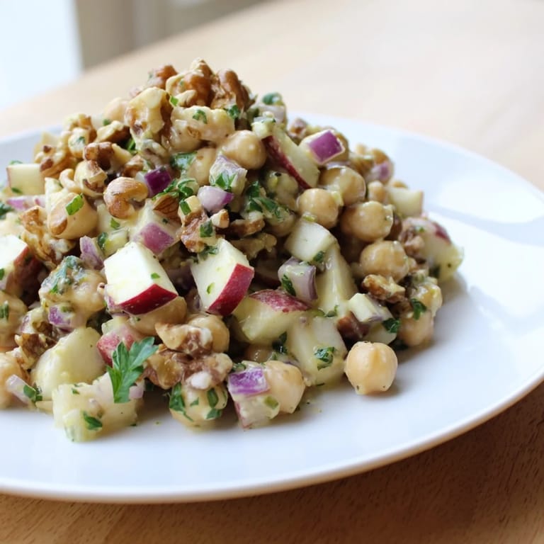 Freshly tossed Fall Harvest Apple and Chickpea Salad, showcasing colorful apples, walnuts, and a zesty honey-mustard dressing.