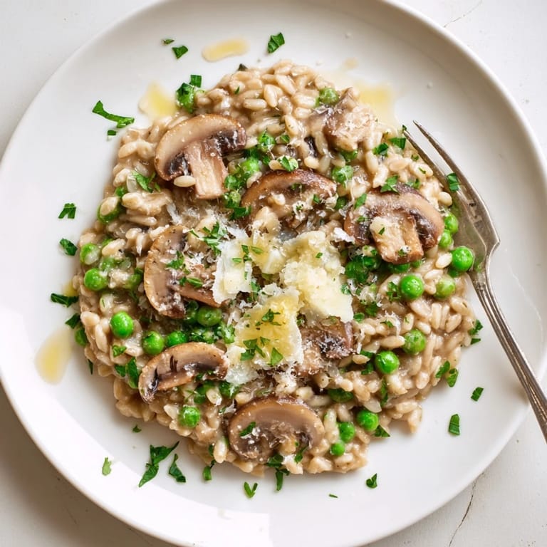 A comforting bowl of Orzo Mushroom Risotto-Style served with a glass of white wine, highlighting its rich, cheesy texture.