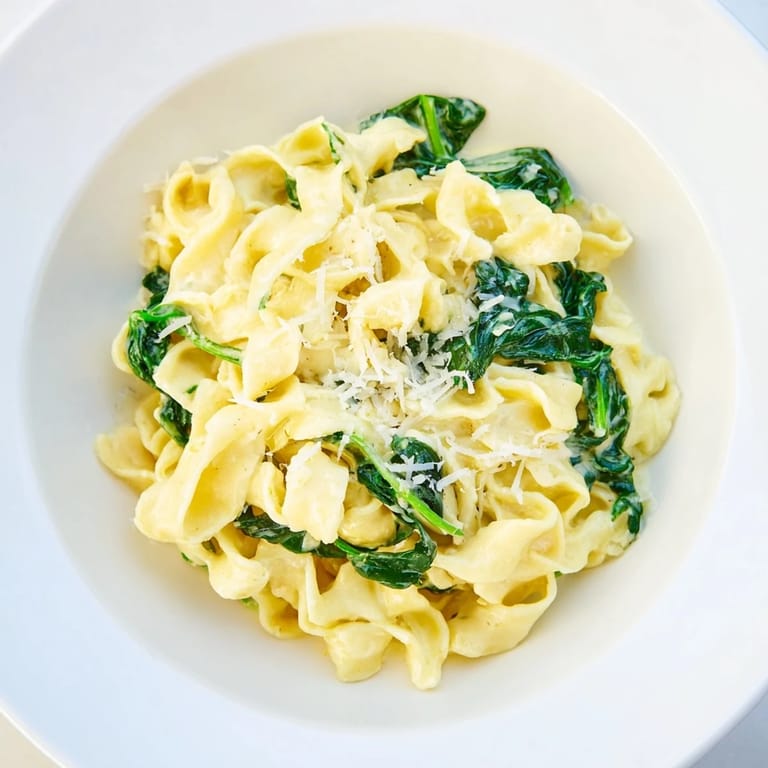 Savory Creamy Spinach Garlic Noodles on a rustic table, garnished with Parmesan and ready to enjoy with garlic bread.