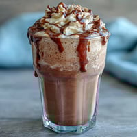 Creamy vanilla bean frappuccino protein shake with frosty ice and vanilla bean specks, perfect for a refreshing breakfast or post-workout treat.